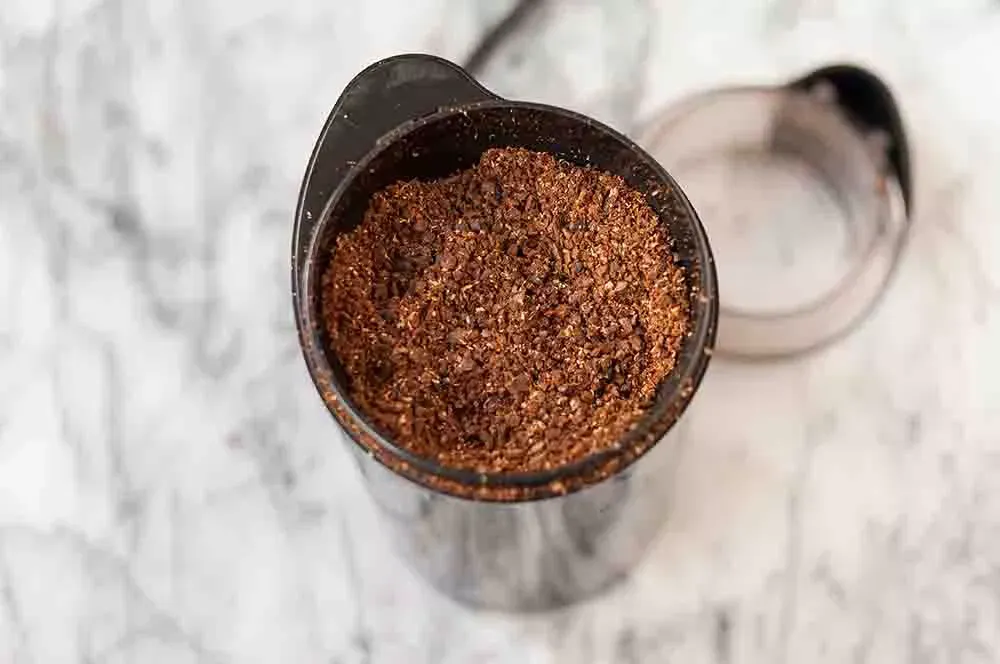 Coarsely grounded coffee beans in an electric grinder