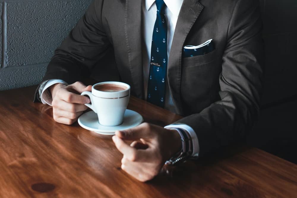a man in a suit having coffee