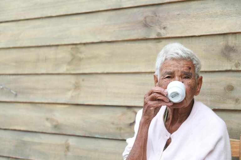 Man drinking coffee from white cup.