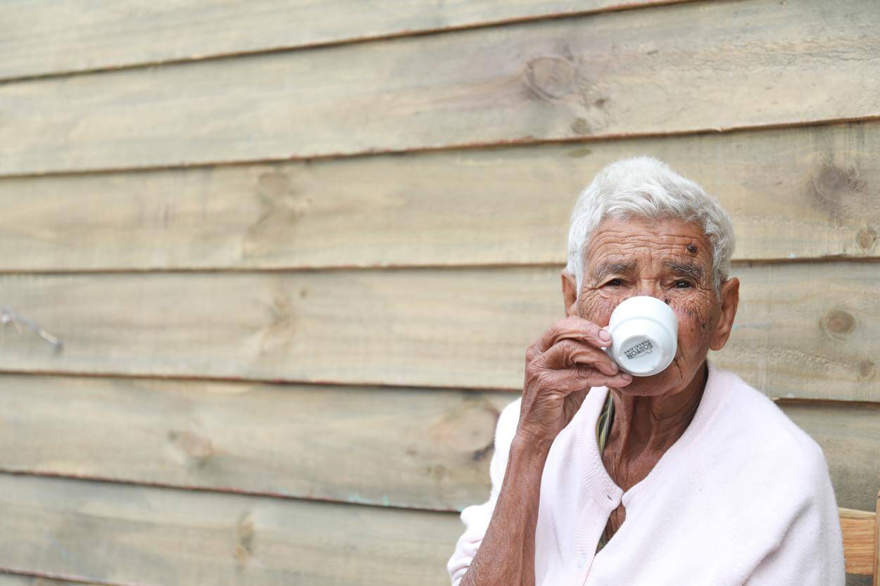 Man drinking coffee from white cup.