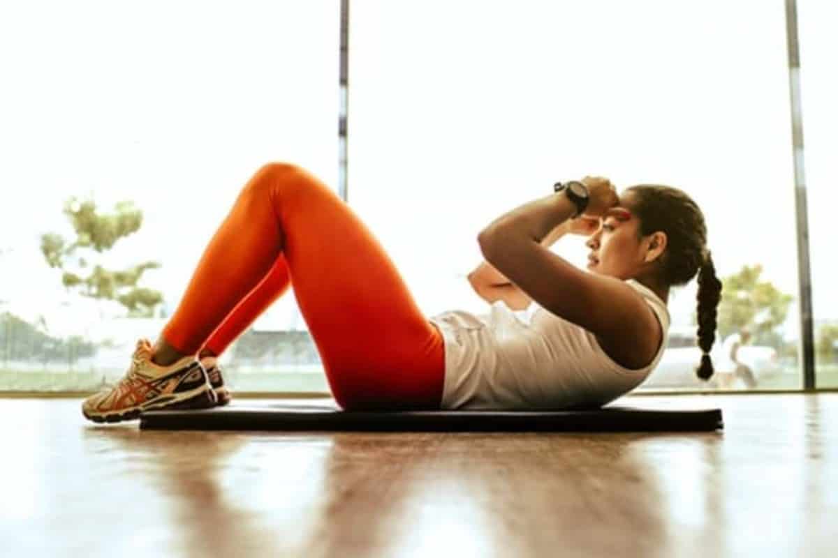 A woman doing sit ups. Exercising is one of the ways to lower blood pressure.