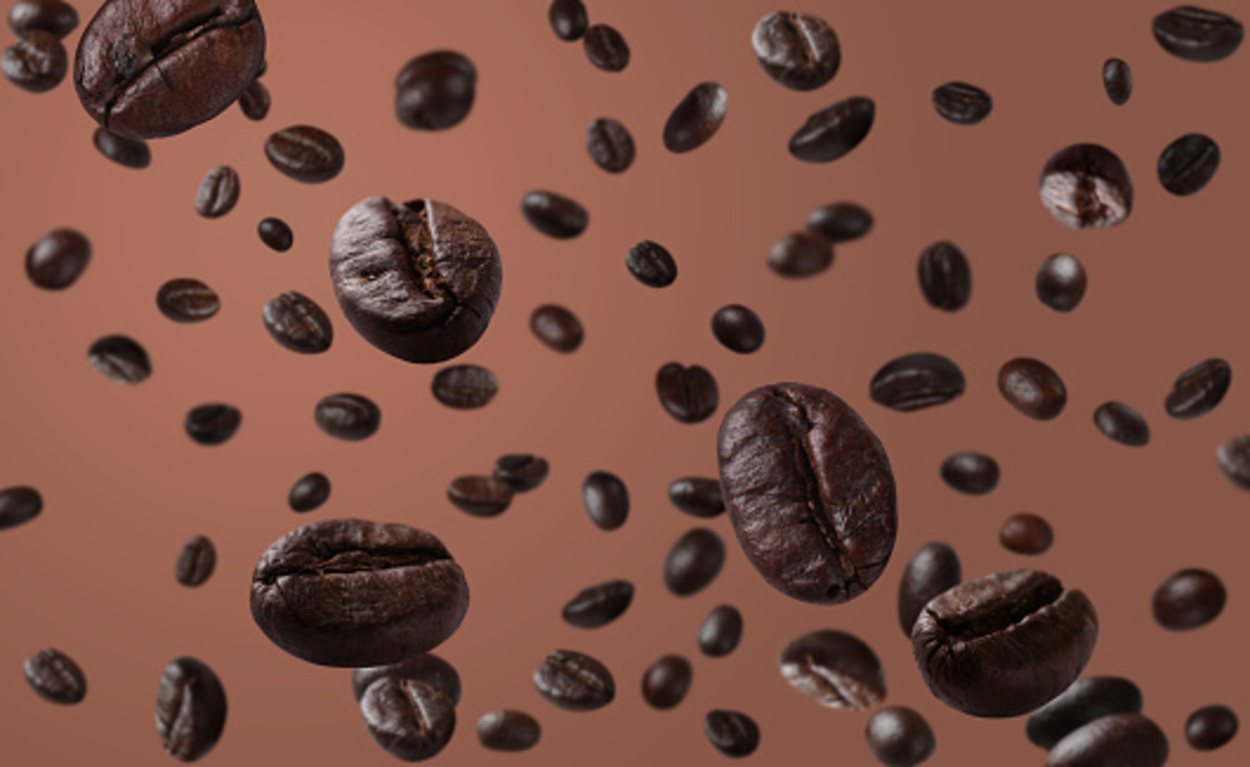 A bunch of coffee beans tossed in the air.