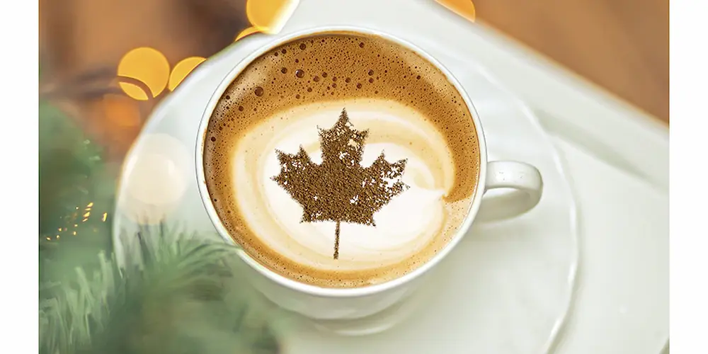 A cup of coffee with a Canadian maple leaf latte art