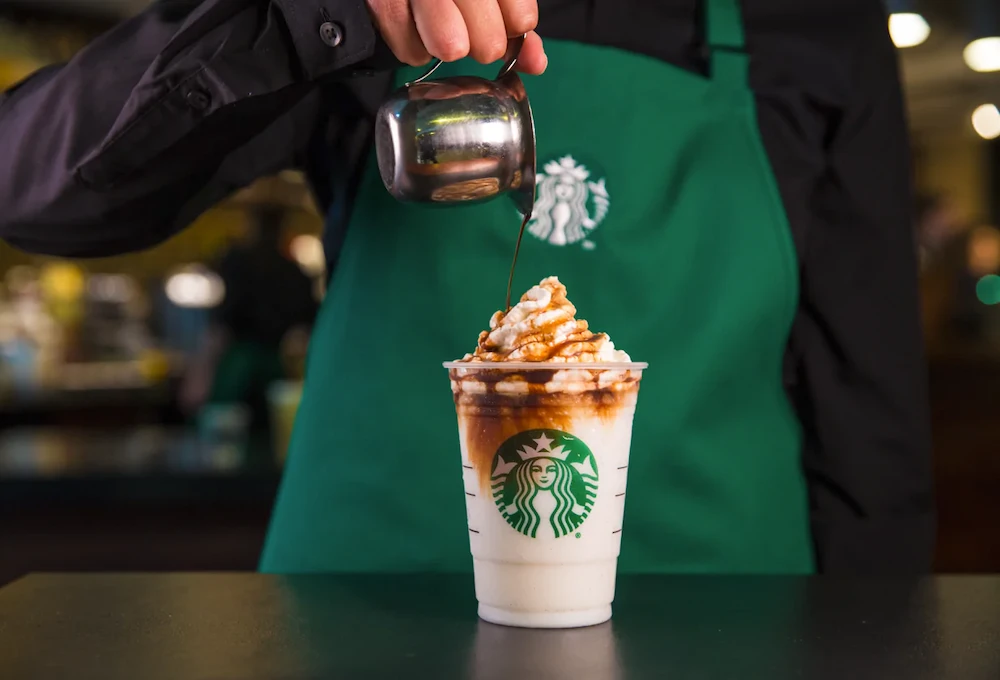 Starbucks barista pouring topping