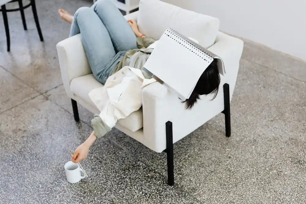 Woman with coffee cup lying on a couch